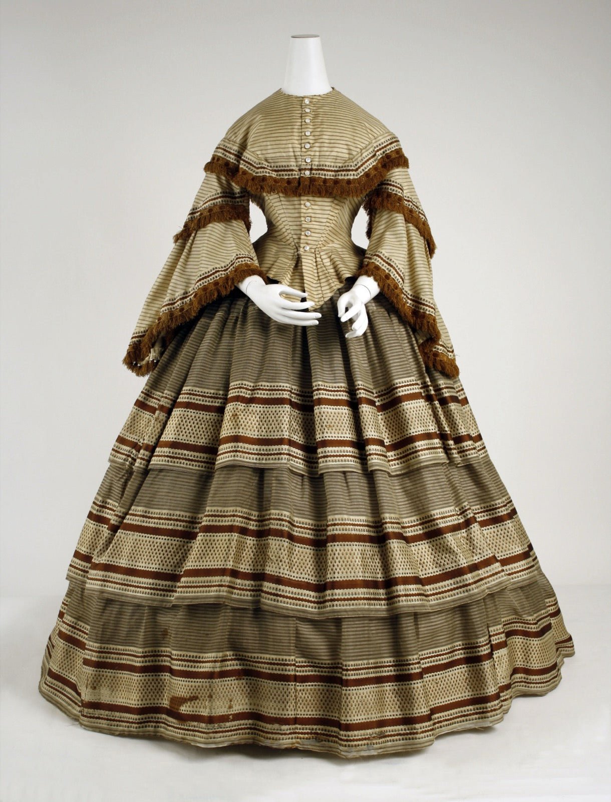 Historic dress with pointed basque waist panel extending below waist seam.