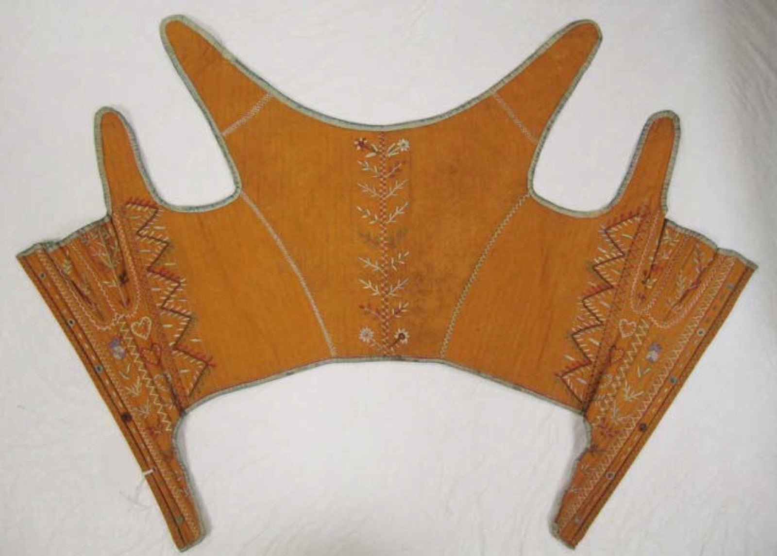 Corset front panel with busk closure on structured undergarment.