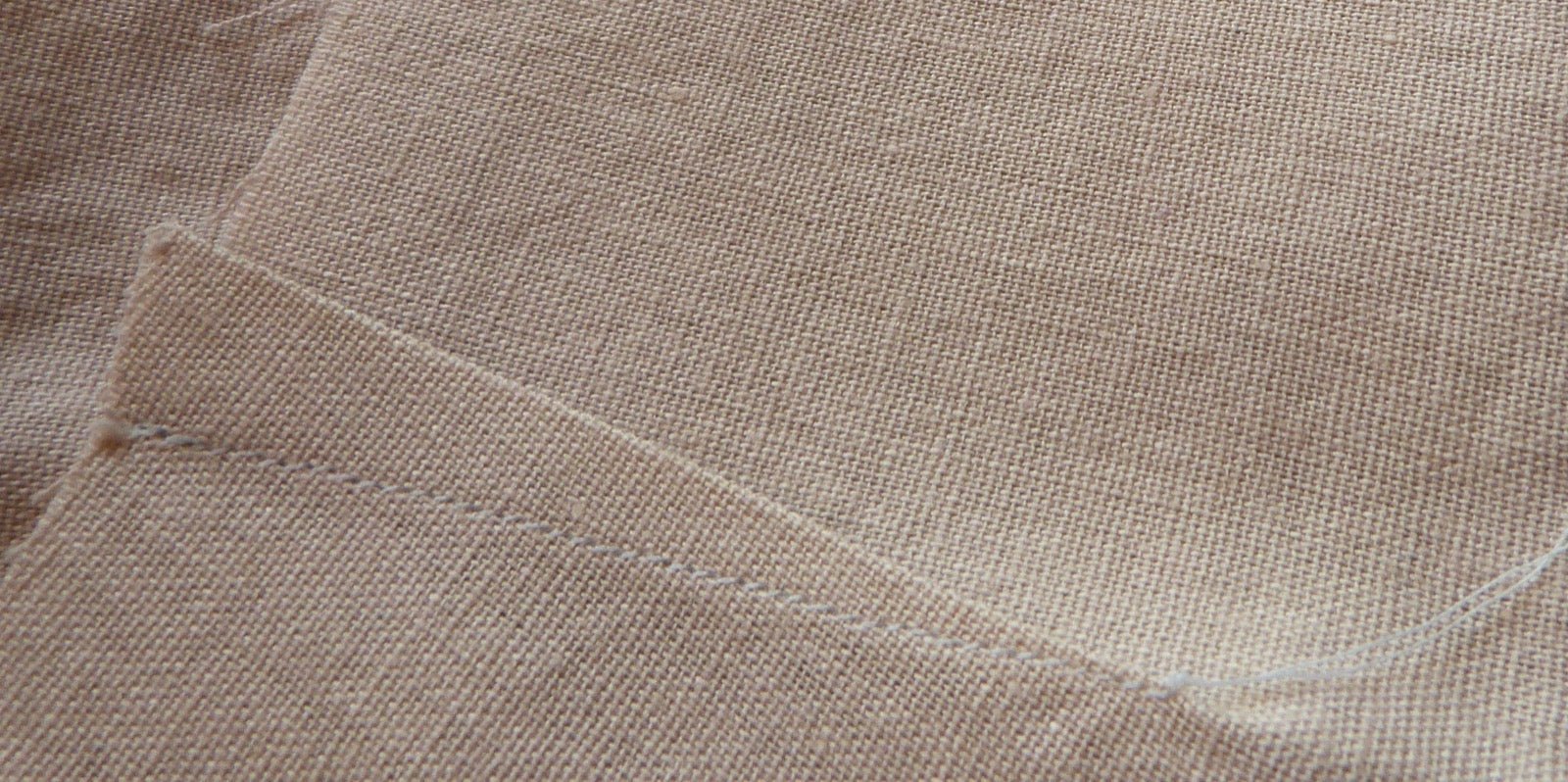 Stitched dart intake removing fabric fullness on bodice panel.