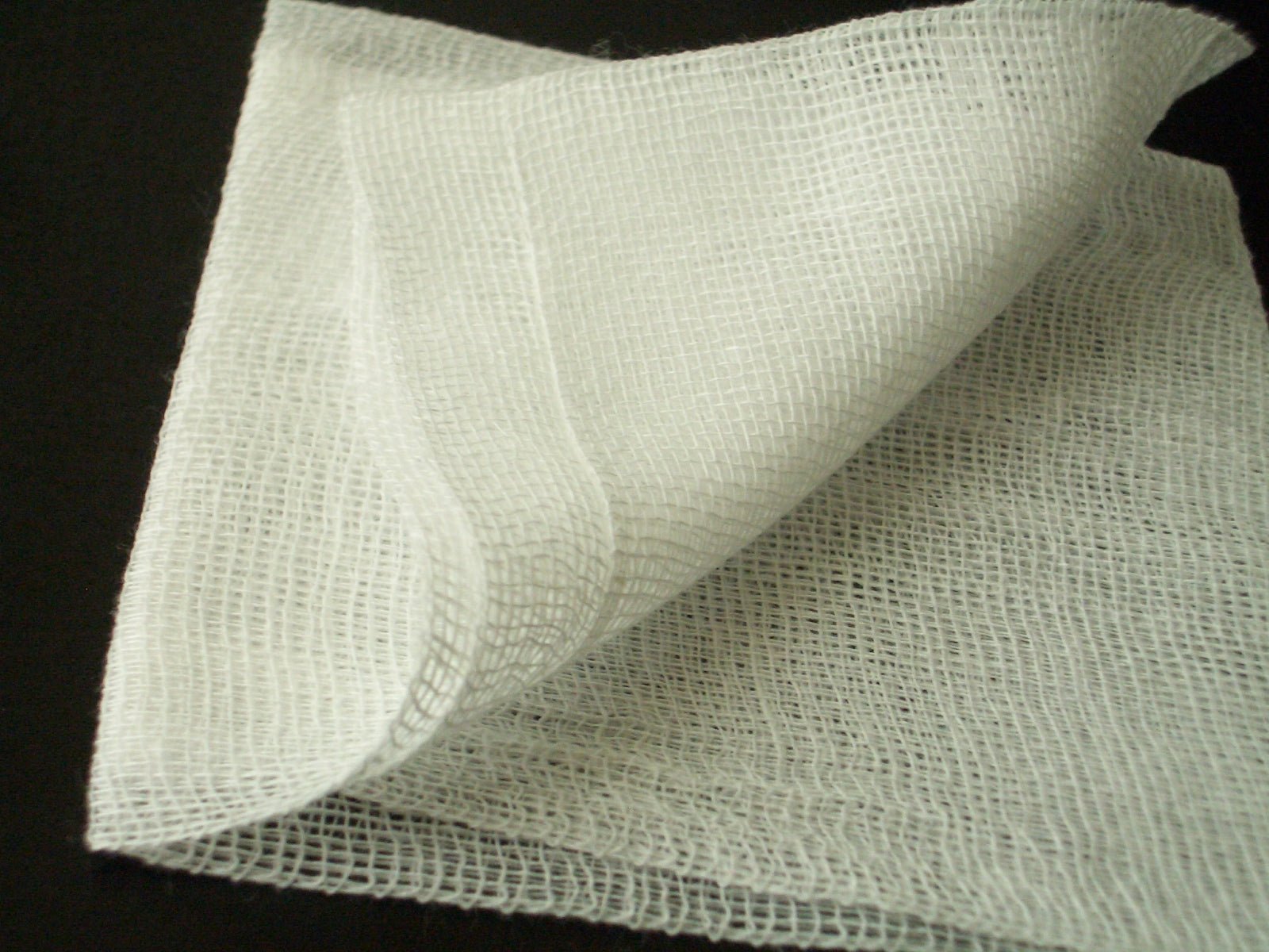 Gauze openwork fabric sample showing sheer perforated mesh.