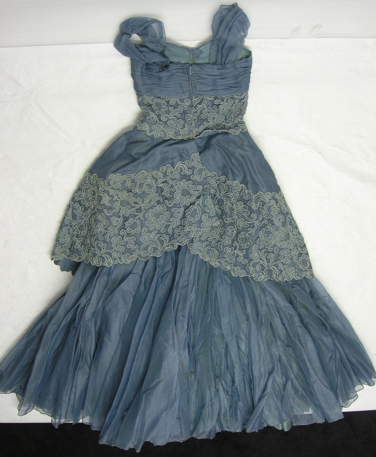Evening dress with organza peplum basque flare at waist panel.