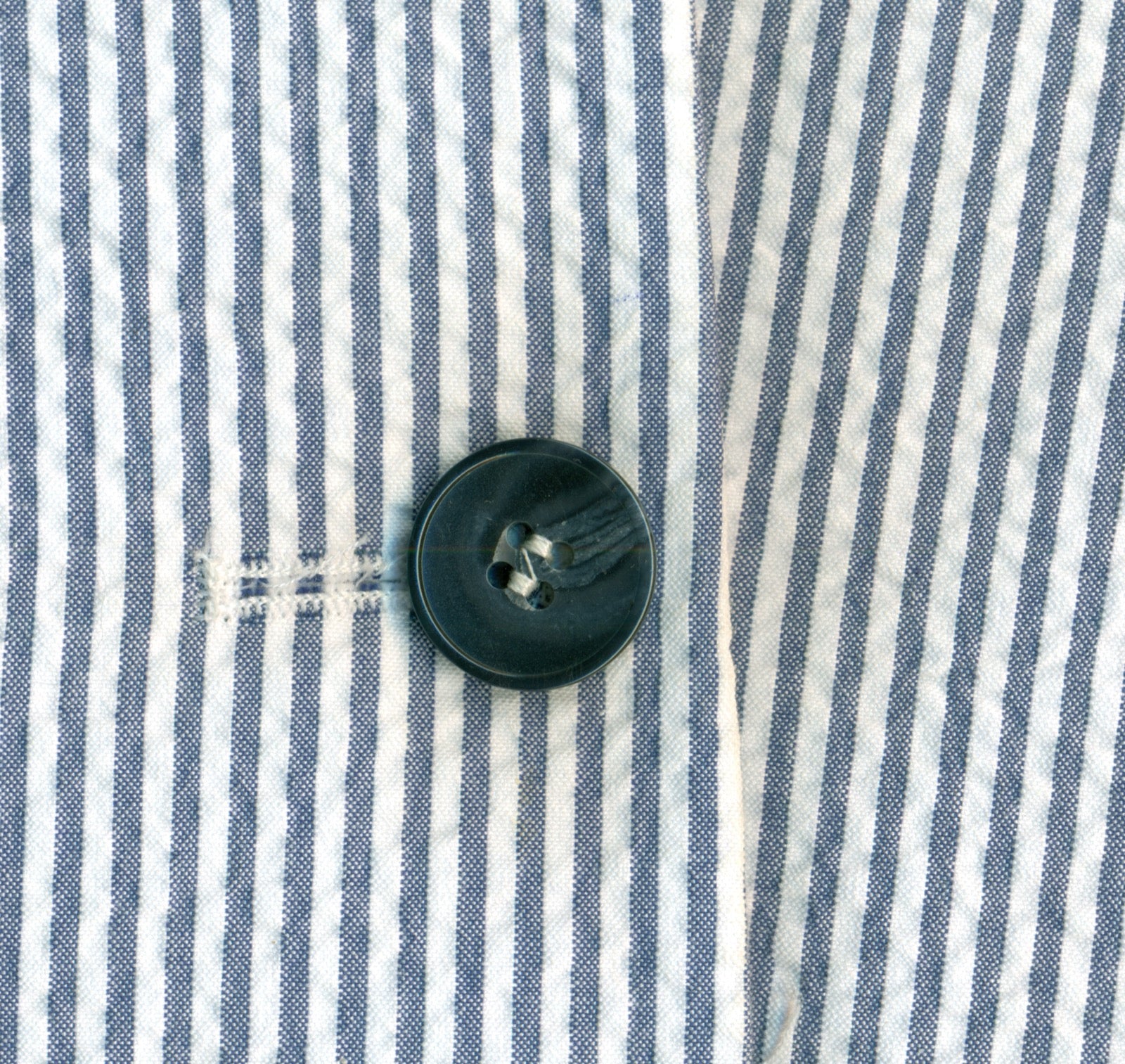 Seersucker cotton fabric sample showing alternating smooth and puckered stripes.