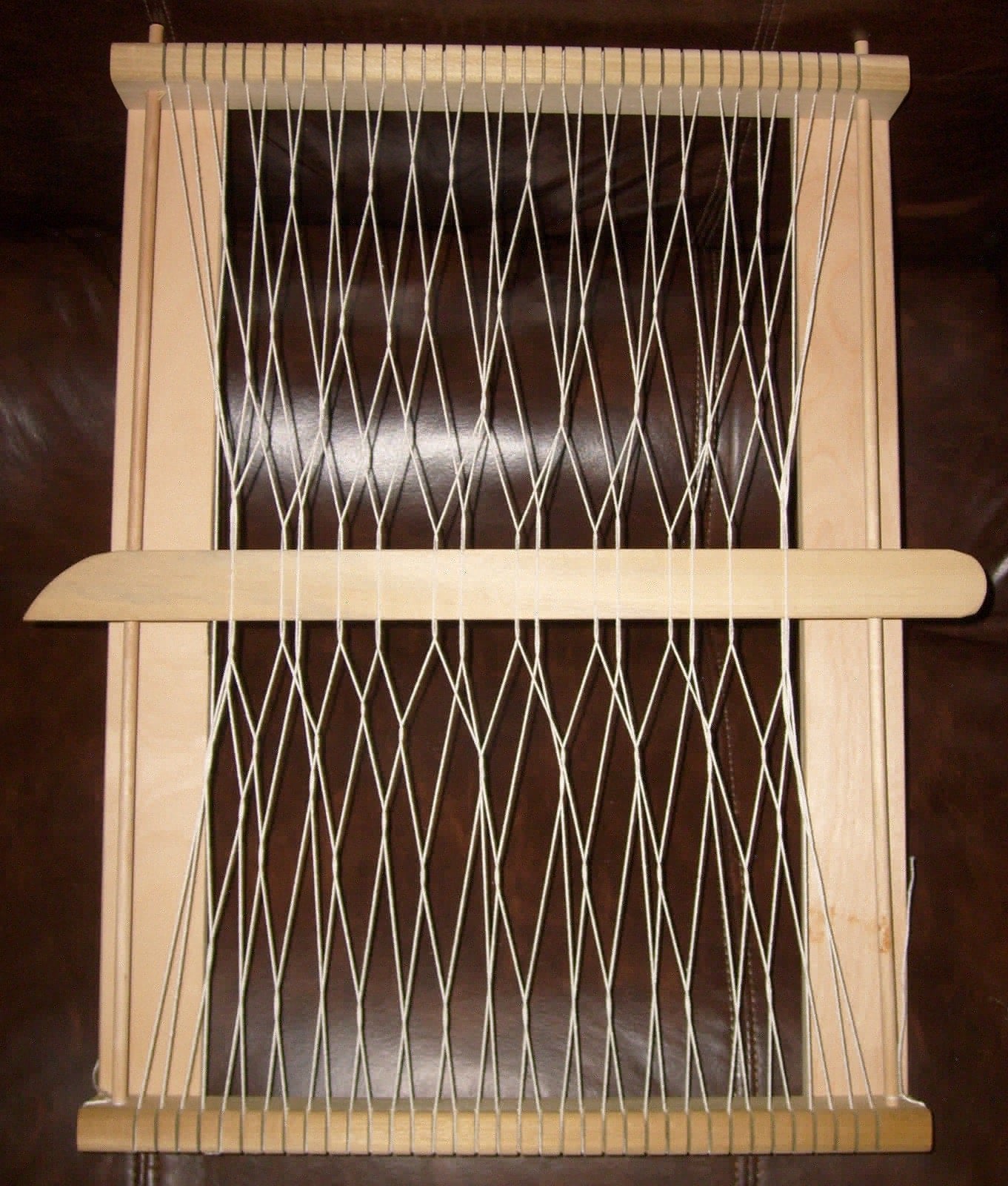 Sprang interlinked warp sample showing open mesh braid structure.