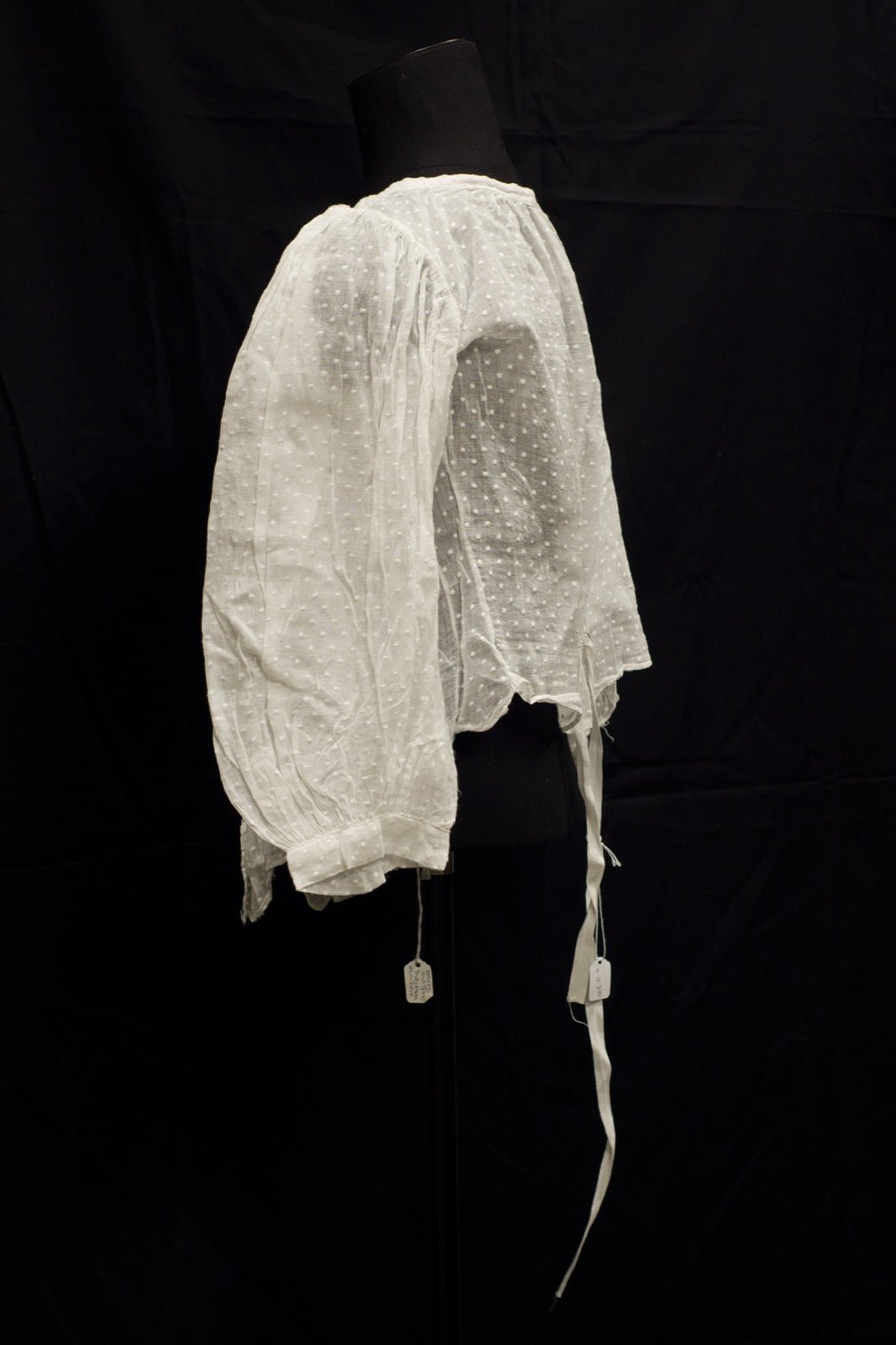 Blouse with fabric tie threaded through a collar loop at the neck.