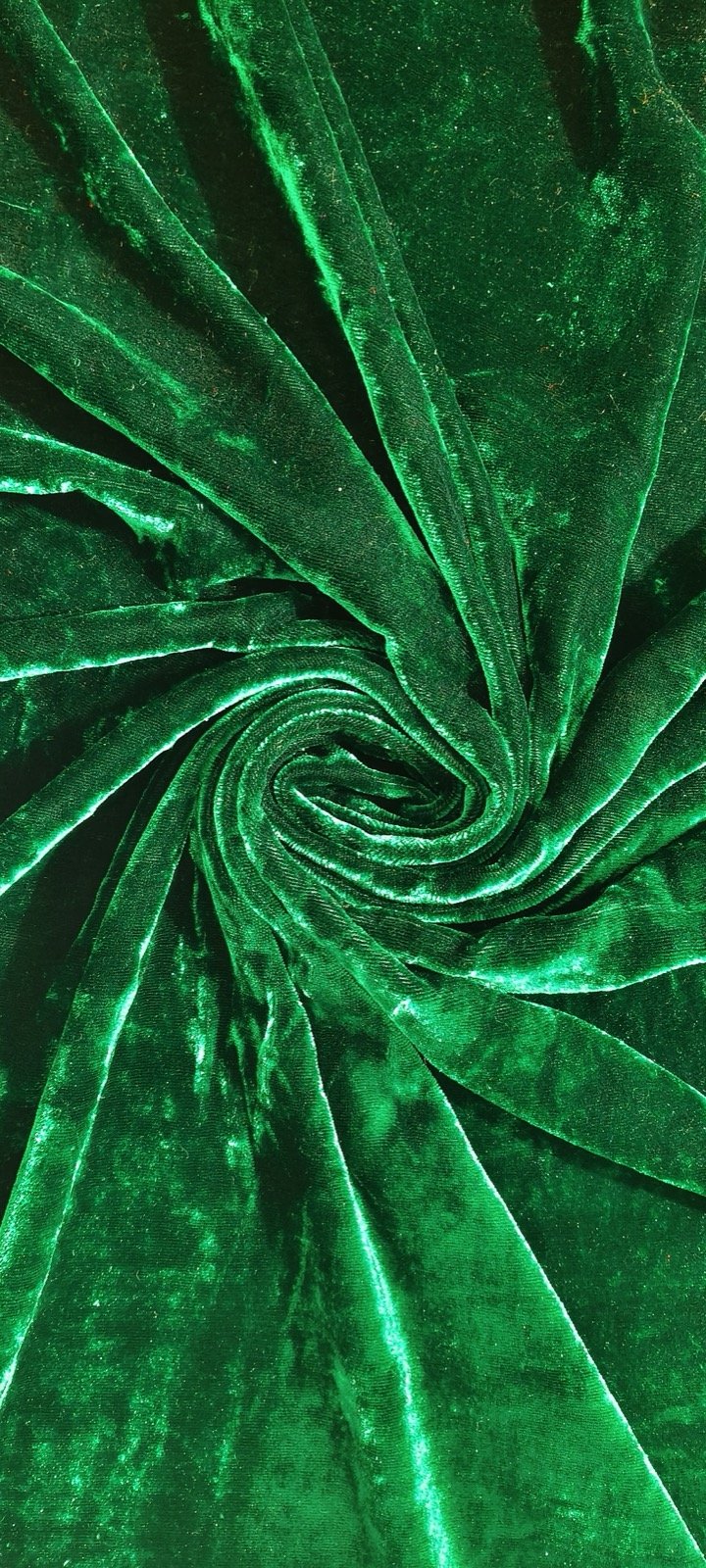 Close-up of green cut-pile velvet fabric showing dense tufts and directional sheen.