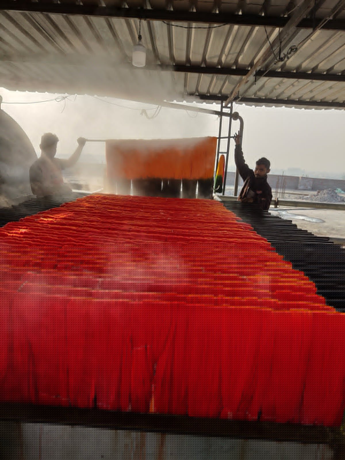 Yarn packages mounted on dyeing frame before weaving plaid stripe fabric.