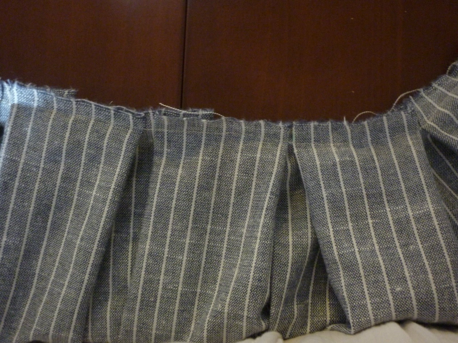 Box pleats with paired folds forming standing volume on fabric.
