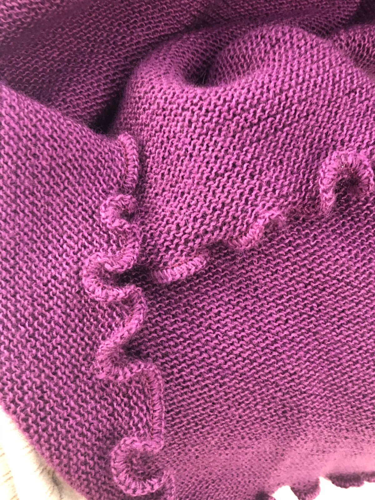 Curled lettuce hem edge on knit fabric panel.