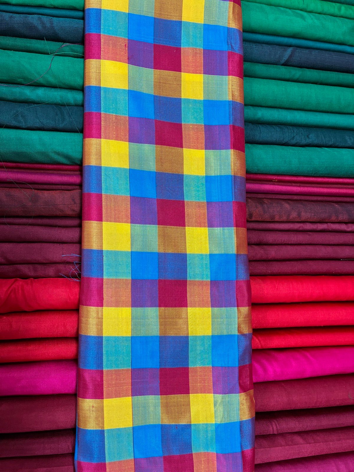 Colourful madras check cotton fabric with bleeding plaid bands.
