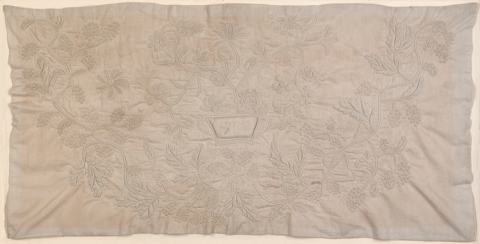Trapunto quilting with stuffed raised channels on pillow sham.